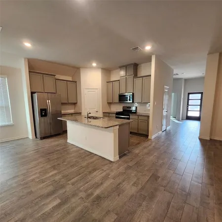 a large kitchen with a refrigerator and a stove top oven
