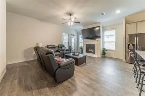 a living room with furniture a flat screen tv and a fireplace
