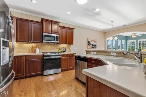 a kitchen with granite countertop a refrigerator and a stove top oven