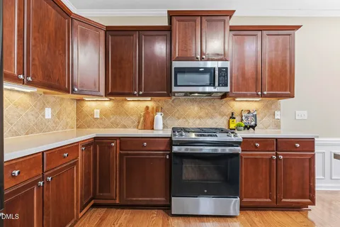 a kitchen with stainless steel appliances granite countertop a sink stove and microwave