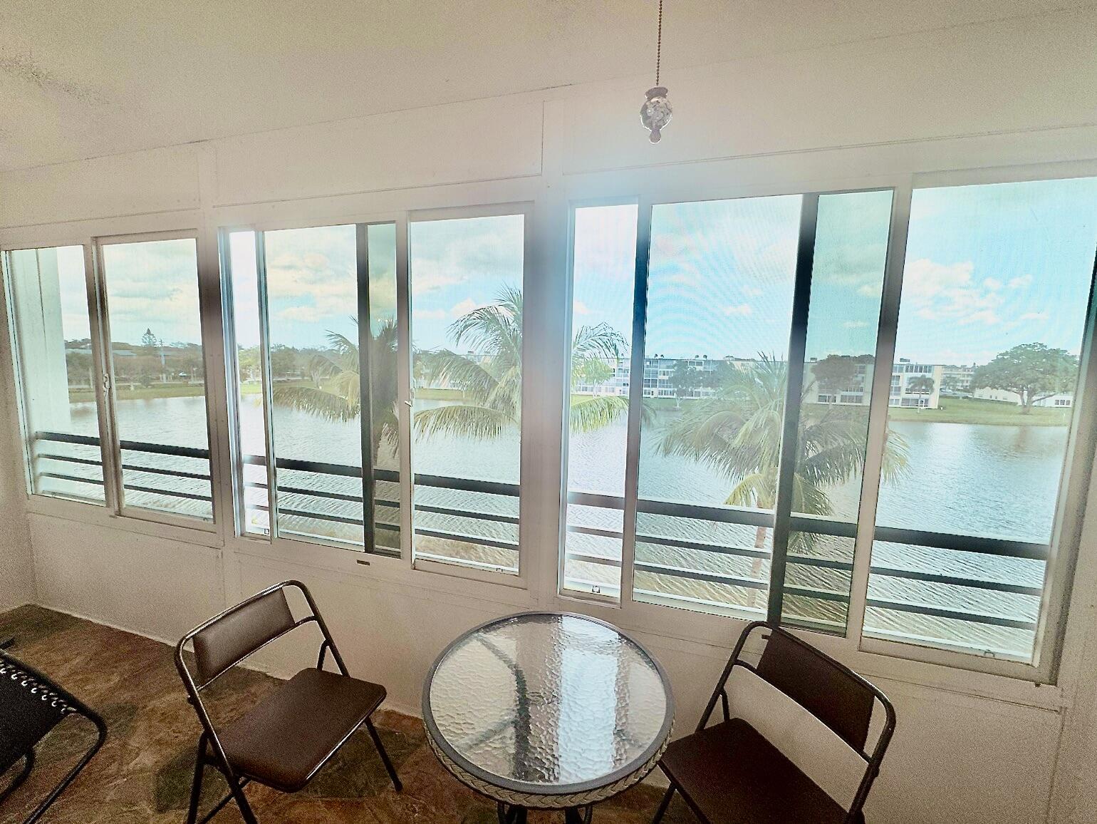 4063 Yarmouth C Boca Raton, FL 33434 - Photo 11 of 27 a bedroom with a balcony a bed and a chair