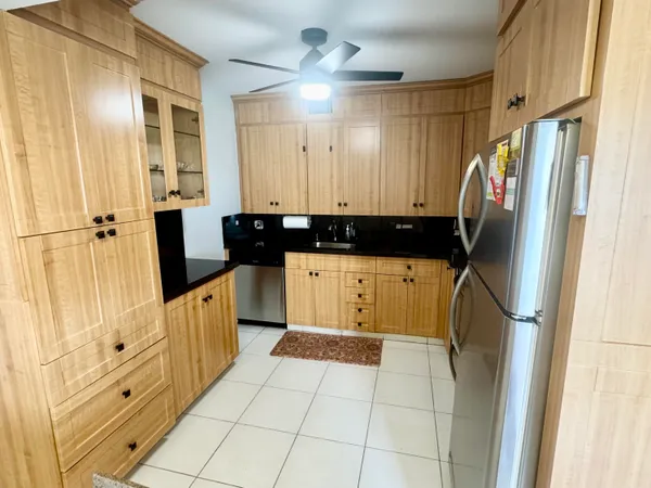 a kitchen with granite countertop a refrigerator a sink and dishwasher
