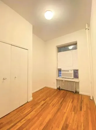 a view of a room with wooden floor and cabinet