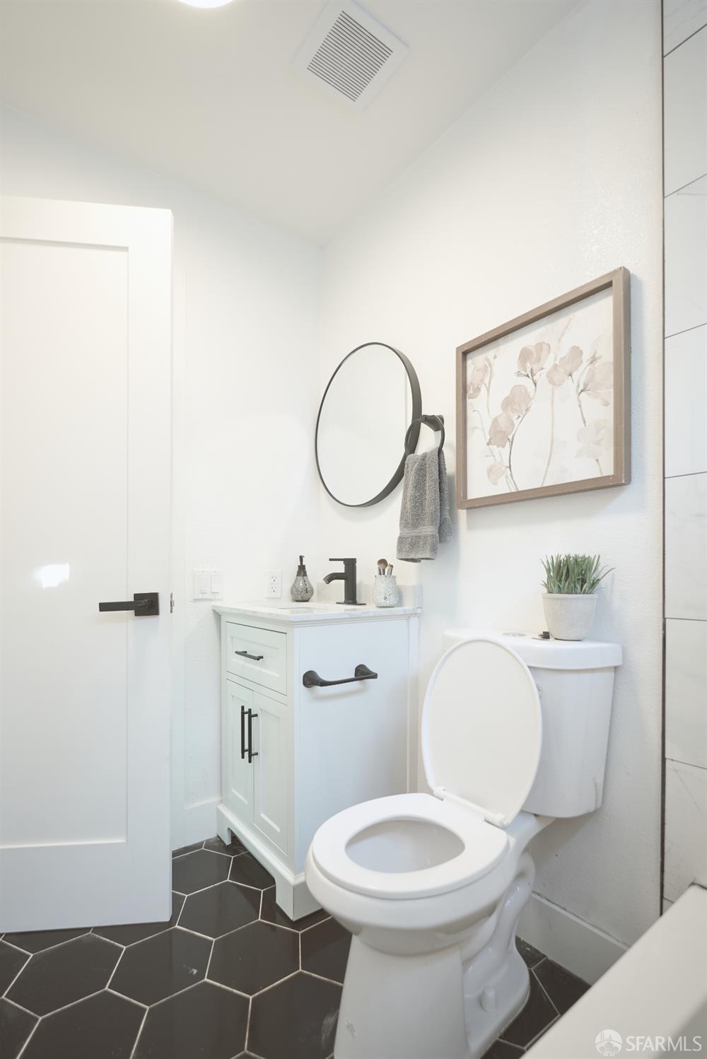 1270 South Van Ness Avenue, Unit A San Francisco, CA 94110 - Photo 24 of 28 a bathroom with a toilet a sink and mirror
