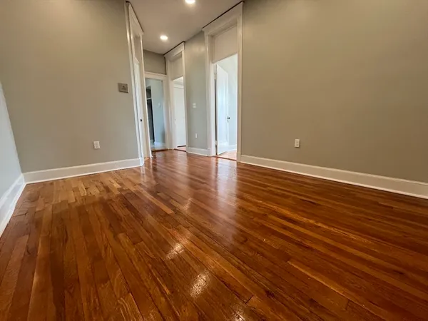 a view of an empty room with wooden floor