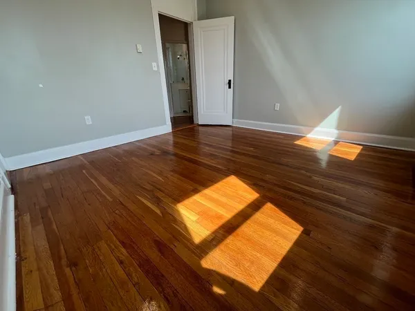 an empty room with wooden floor and a window
