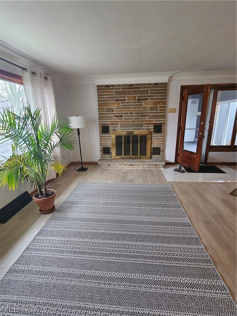 3700 Jaeger Road Lorain, OH 44053 - Photo 15 of 50 Unfurnished living room with ornamental molding, light hardwood / wood-style floors, and a fireplace