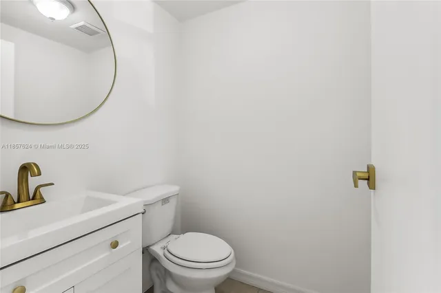 a bathroom with a sink mirror and toilet