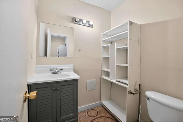 a bathroom with a sink toilet and mirror