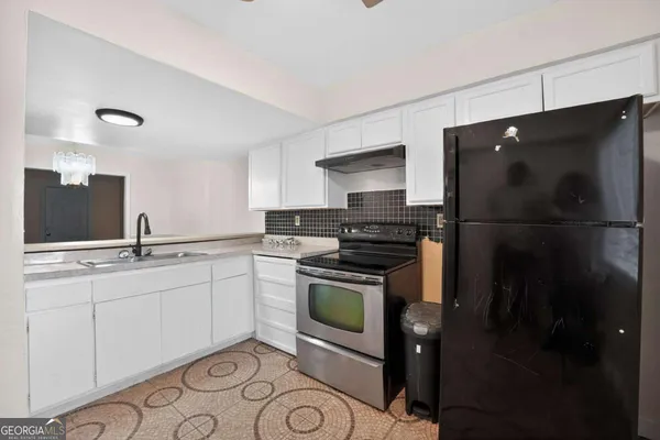 a kitchen with a sink appliances and cabinets