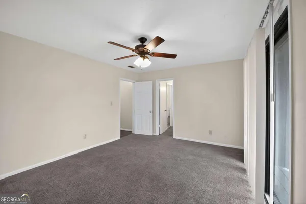 a view of a room with a ceiling fan and a window