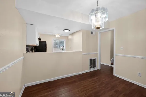 a view of a room with wooden floor and chandelier