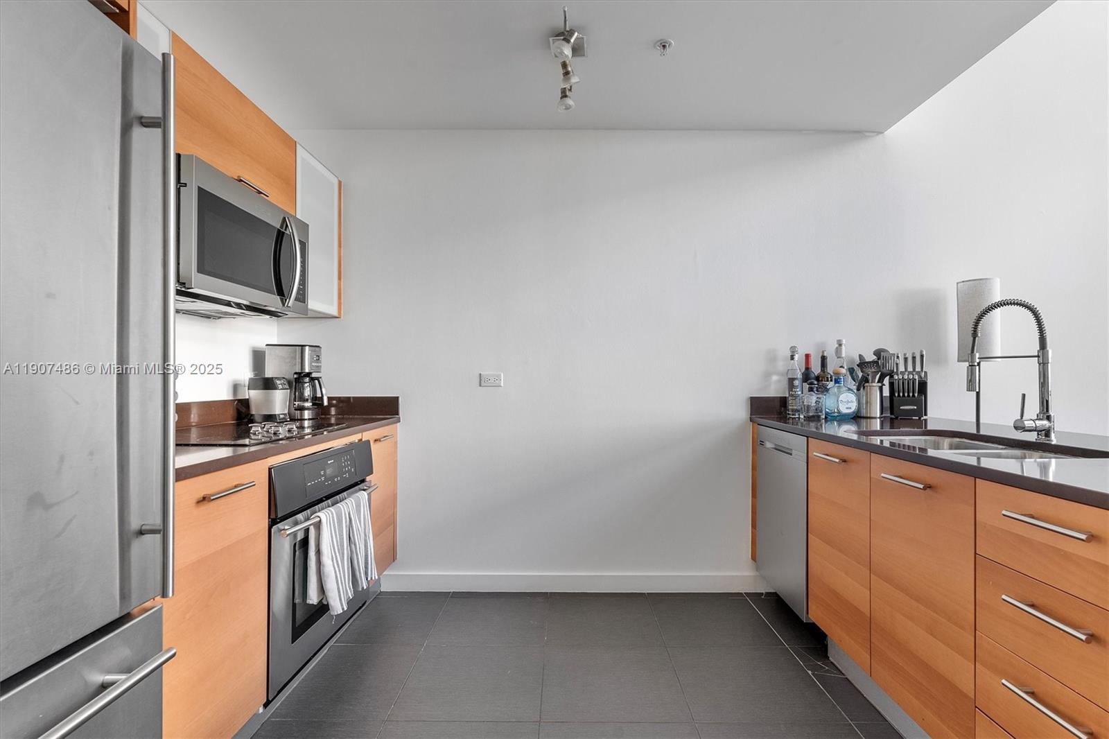 3301 Northeast 1st Avenue, Unit M0502 Miami, FL 33137 - Photo 7 of 29 a kitchen with stainless steel appliances a sink stove top oven and refrigerator