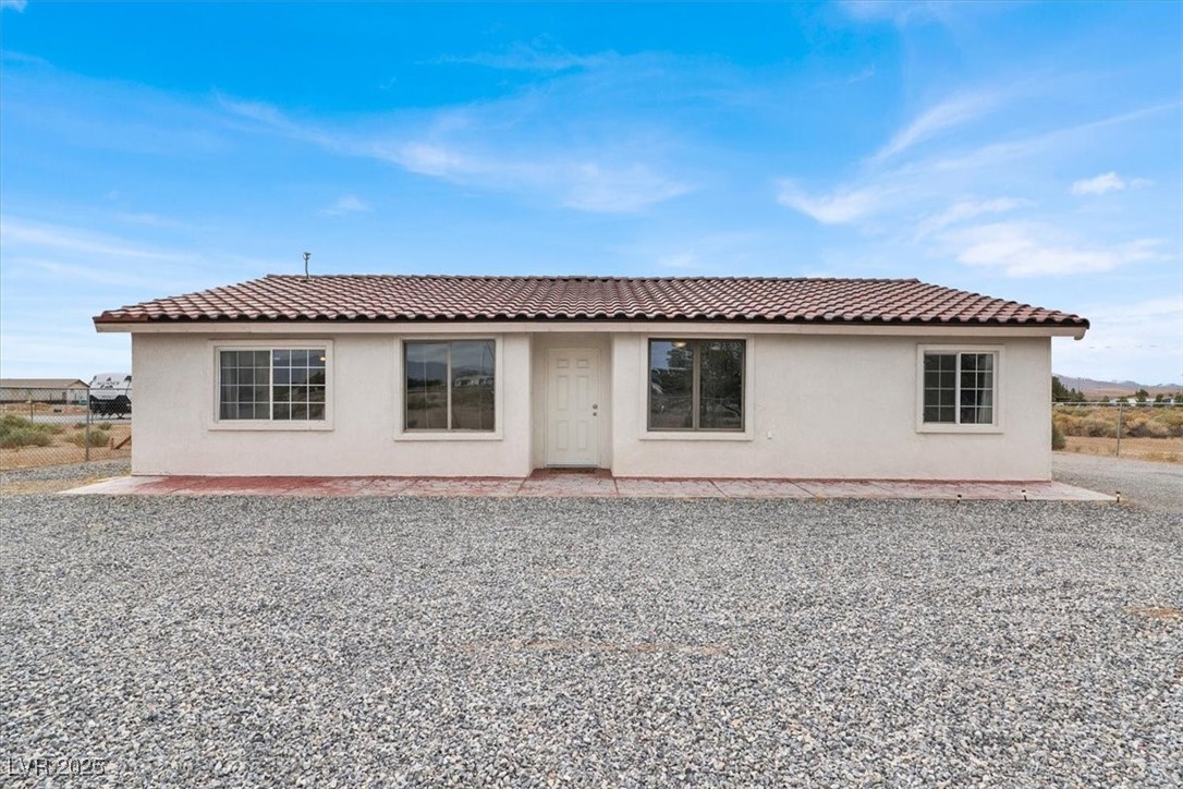 4391 Emma Street Pahrump, NV 89048 - Photo 2 of 28 Rear view of house with stucco siding and a tile roof