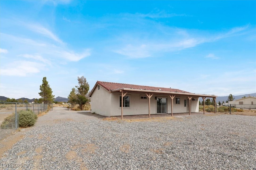 4391 Emma Street Pahrump, NV 89048 - Photo 25 of 28 Back of house featuring stucco siding, a tile roof, and a mountain view
