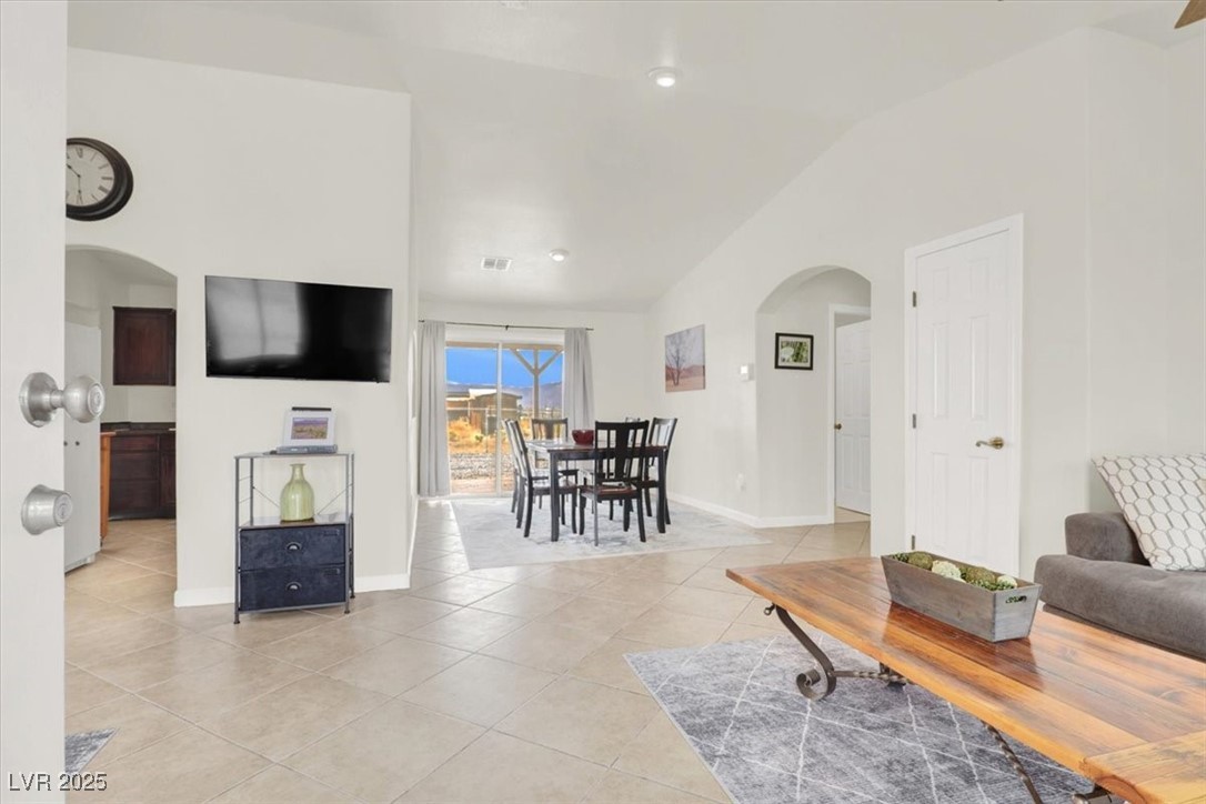4391 Emma Street Pahrump, NV 89048 - Photo 7 of 28 Living area featuring arched walkways, lofted ceiling, and light tile patterned flooring