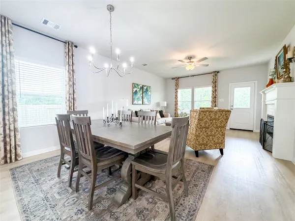 a dining room with furniture a chandelier and wooden floor