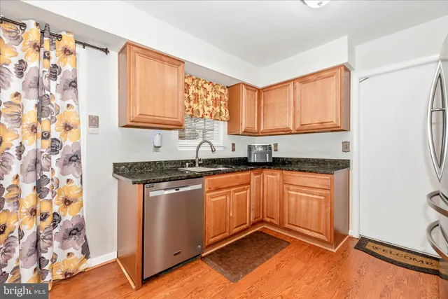 a kitchen with granite countertop a refrigerator stove and sink