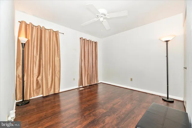 an empty room with a ceiling fan and carpet