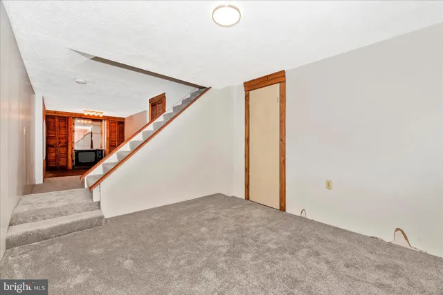 a view of an empty room with a fireplace and a window