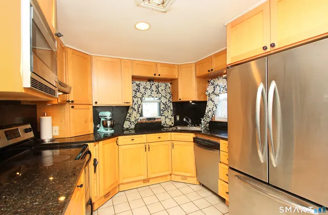 a kitchen with stainless steel appliances a refrigerator sink and cabinets