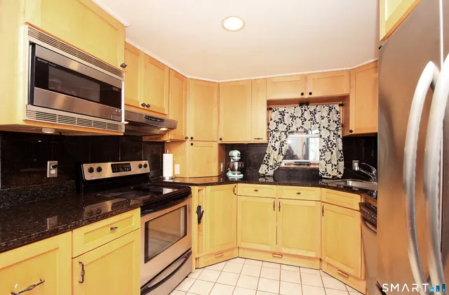 a kitchen with stainless steel appliances a stove microwave and sink