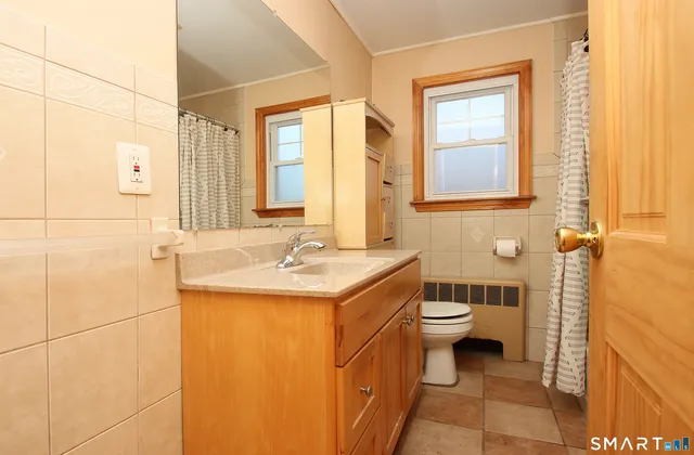 a bathroom with a toilet sink and mirror