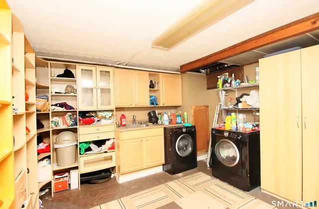 a utility room with fridge dryer and washer
