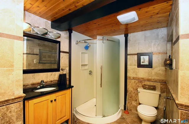 a bathroom with a granite countertop sink toilet and shower