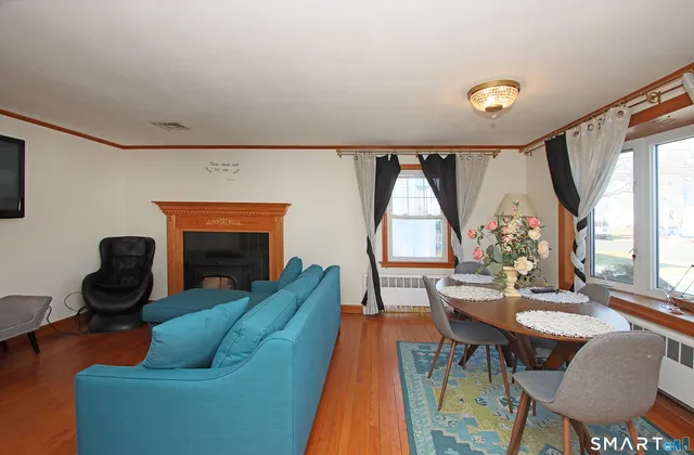 a living room with furniture a fireplace and a large window