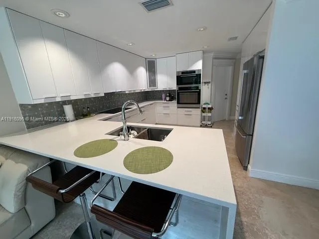 a kitchen with a refrigerator and a sink