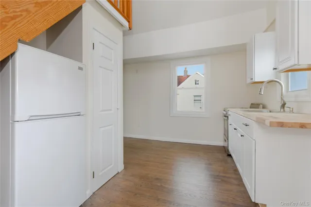 a kitchen with a refrigerator sink and white cabinets