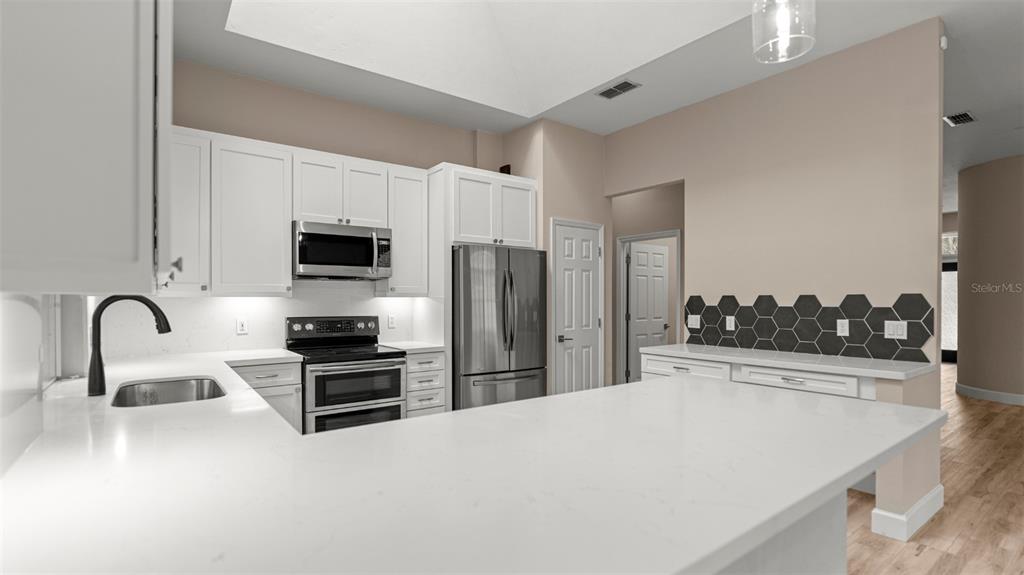 9428 Southwest 39 Avenue Gainesville, FL 32608 - Photo 16 of 43 a kitchen with stainless steel appliances kitchen island a sink a stove and cabinets