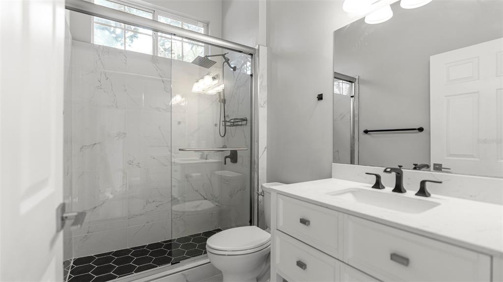9428 Southwest 39 Avenue Gainesville, FL 32608 - Photo 20 of 43 a bathroom with a sink a toilet a shower and a mirror