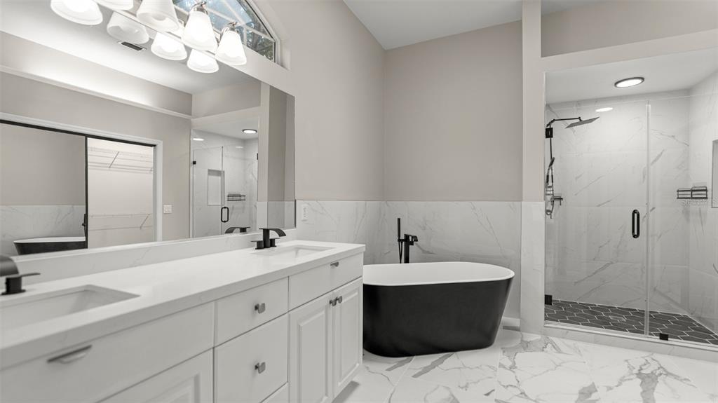 9428 Southwest 39 Avenue Gainesville, FL 32608 - Photo 28 of 43 a bathroom with a sink a large mirror and shower
