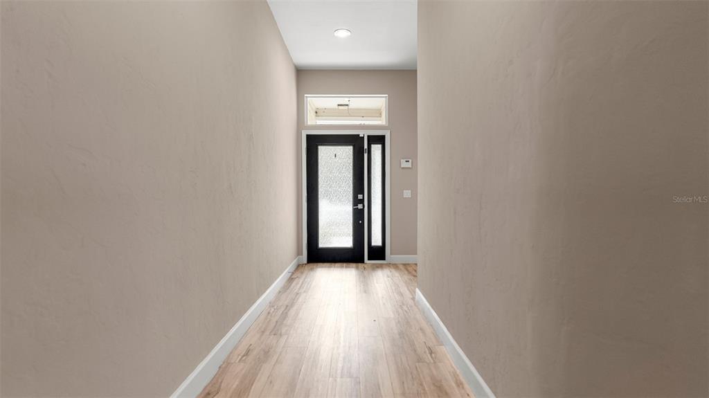 9428 Southwest 39 Avenue Gainesville, FL 32608 - Photo 5 of 43 a view of a hallway with wooden floor and a hallway
