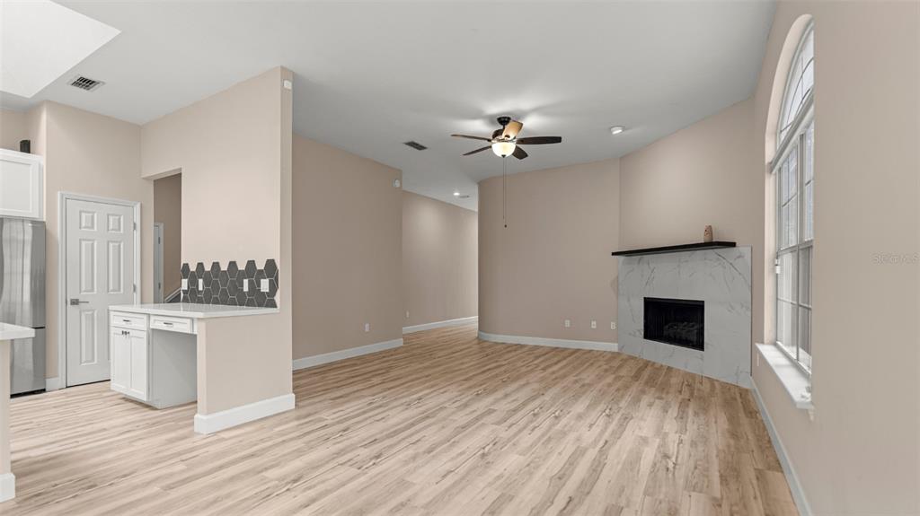 9428 Southwest 39 Avenue Gainesville, FL 32608 - Photo 8 of 43 a view of an empty room with a kitchen and a fireplace