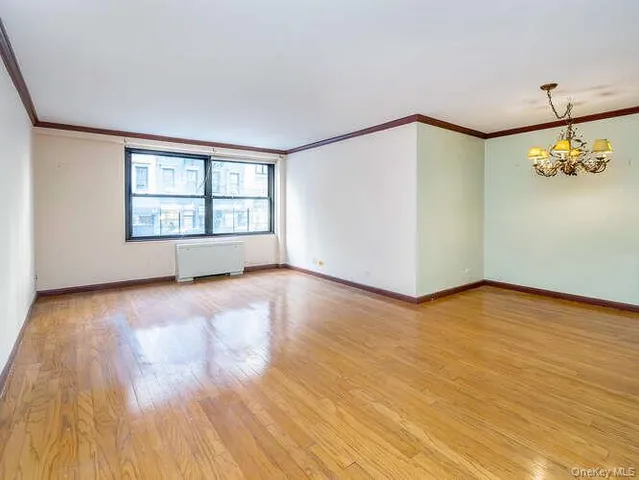 a view of an empty room with glass door and wooden floor
