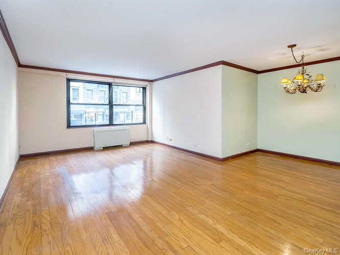 225 East 57th Street, Unit 1L Manhattan, NY 10022 - Photo 13 of 20 a view of an empty room with glass door and wooden floor