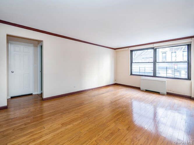 225 East 57th Street, Unit 1L Manhattan, NY 10022 - Photo 16 of 20 a view of an empty room with wooden floor and a window
