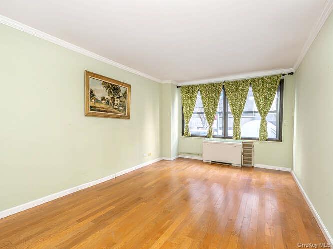 225 East 57th Street, Unit 1L Manhattan, NY 10022 - Photo 18 of 20 an empty room with wooden floor and windows