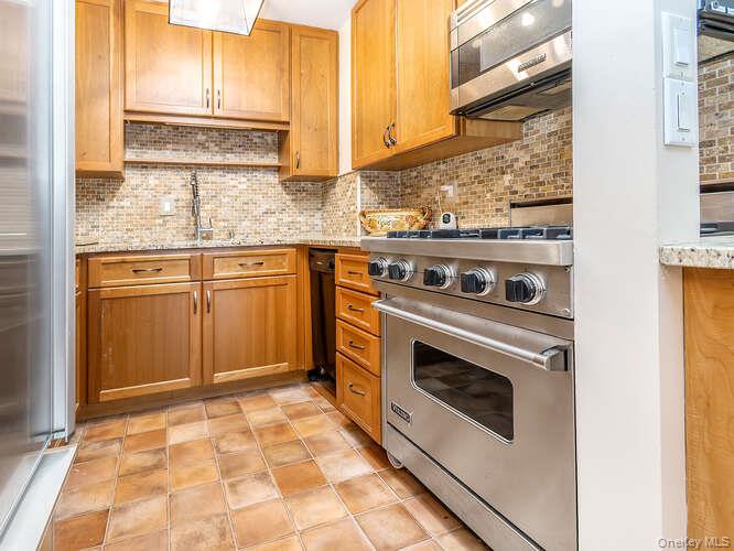 225 East 57th Street, Unit 1L Manhattan, NY 10022 - Photo 10 of 20 a kitchen with stainless steel appliances granite countertop a stove a sink and a microwave
