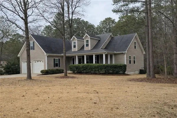 a front view of a house with a yard covered in snow