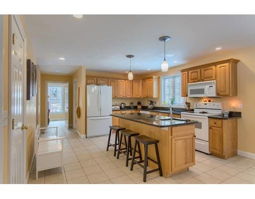 85 Chicopee Row Groton, MA 01450 - Photo 2 of 30 a kitchen with stainless steel appliances kitchen island granite countertop a refrigerator a stove a sink a dining table and chairs