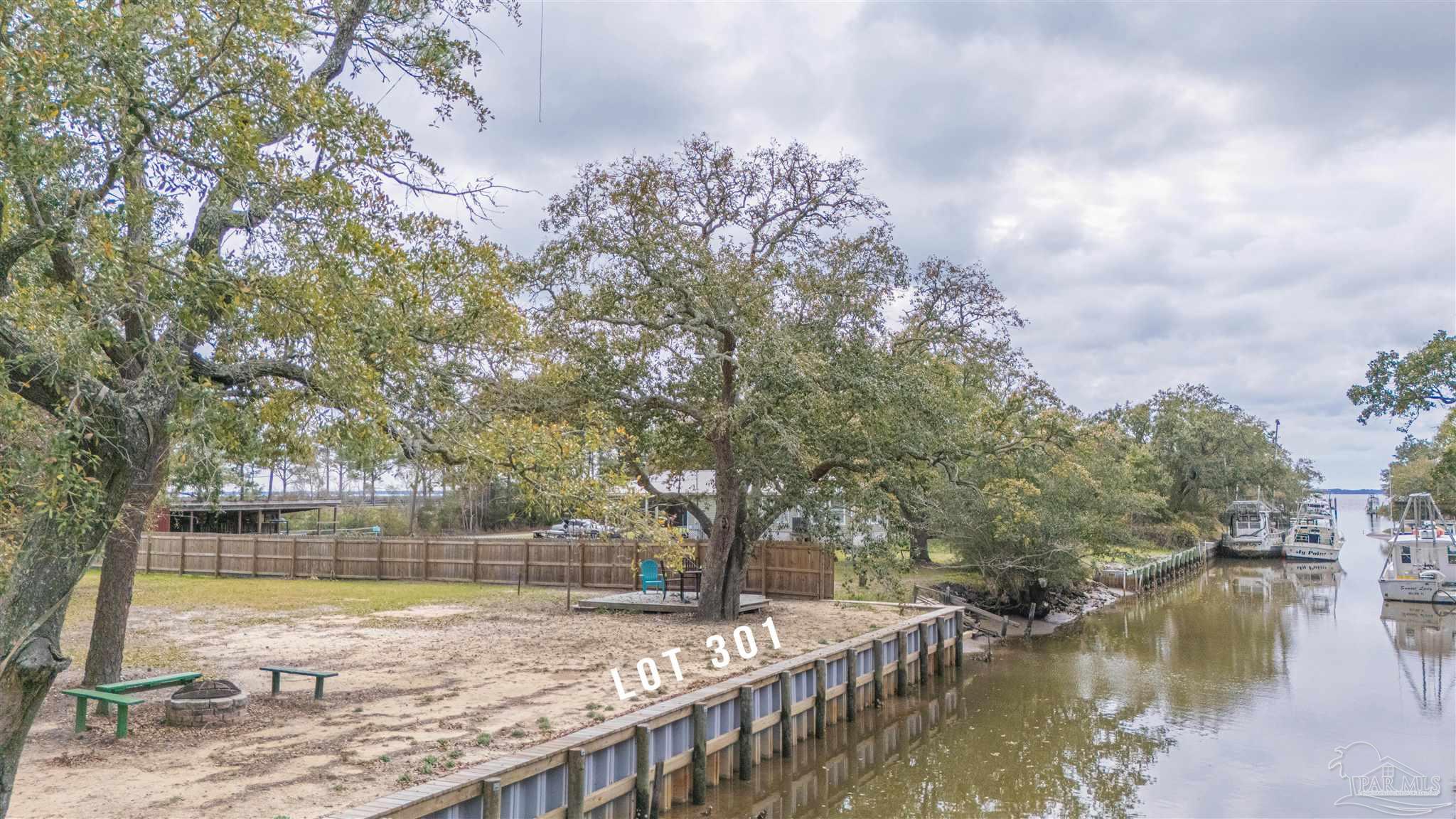 a view of a lake with a yard and large trees