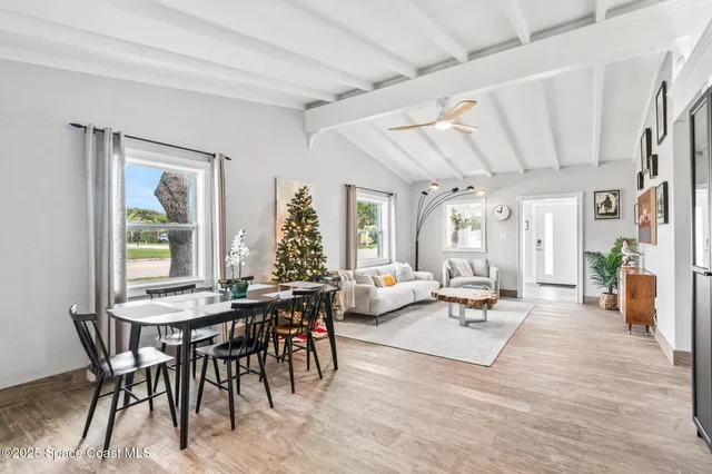 a kitchen with a sink stove and white cabinets with wooden floor