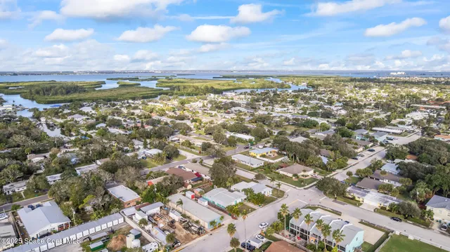 an aerial view of a swimming pool with lawn chairs and large trees