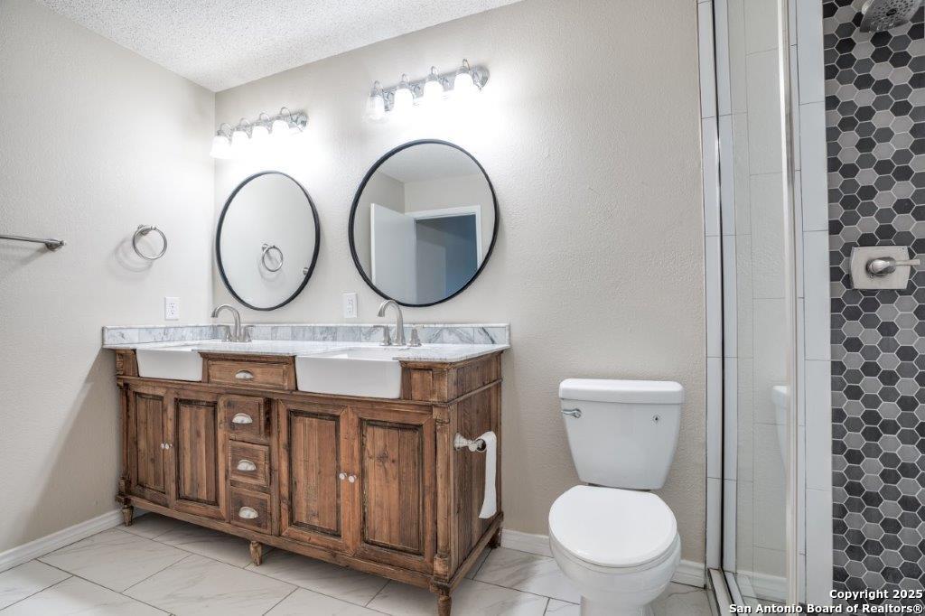 218 Ebner Street Boerne, TX 78006 - Photo 18 of 24 a bathroom with a toilet a sink and a mirror