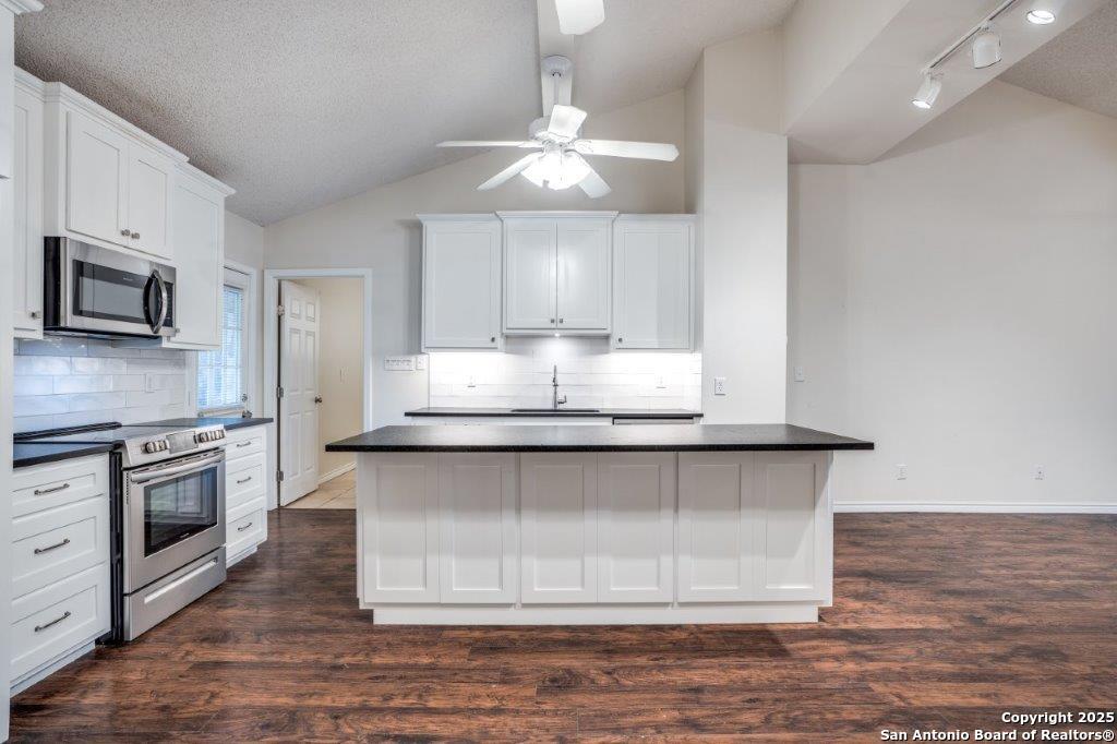 218 Ebner Street Boerne, TX 78006 - Photo 9 of 24 a kitchen with stainless steel appliances granite countertop a stove a sink and a microwave