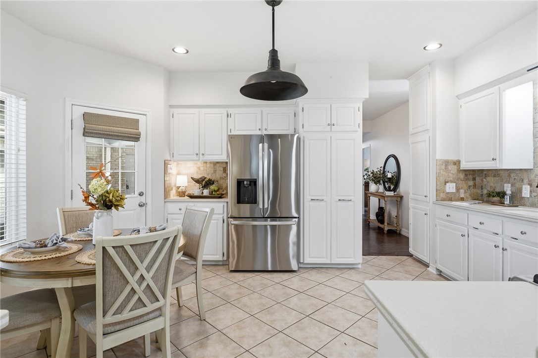 616 Colonial Drive Portland, TX 78374 - Photo 10 of 35 a kitchen with stainless steel appliances granite countertop a refrigerator a stove a sink a dining table and chairs with wooden floor